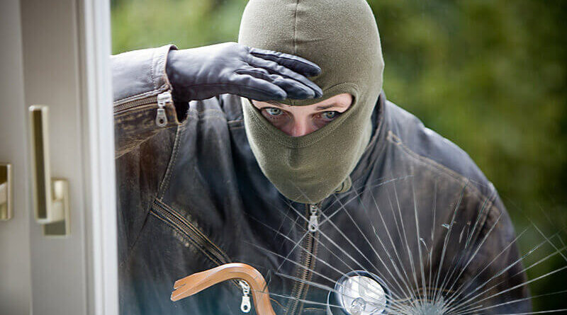 Sicherheitsfolie - Ein Einbrecher schaut durch eine Fensterscheibe