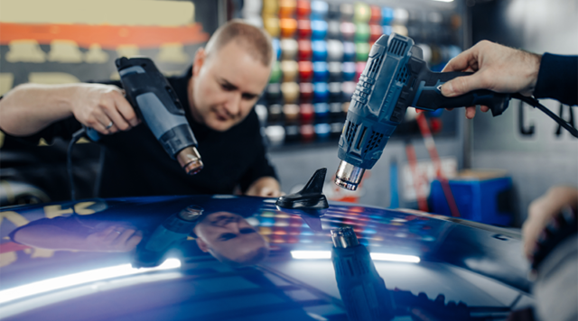 Glanzfolie wird auf dem Auto verklebt